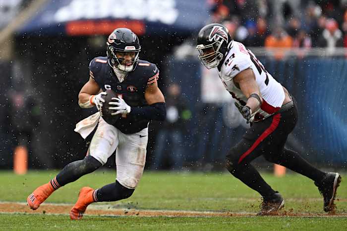 Dec 31, 2023; Chicago, Illinois, USA; Chicago Bears quarterback Justin Fields (1) scrambles away from Atlanta Falcons defensive lineman Calais Campbell (93) in the first half at Soldier Field.